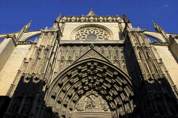SPAIN, Andalucia, Seville, Angled view looking up at the Puerta de la Asuncion gothic style portal of the Cathedral