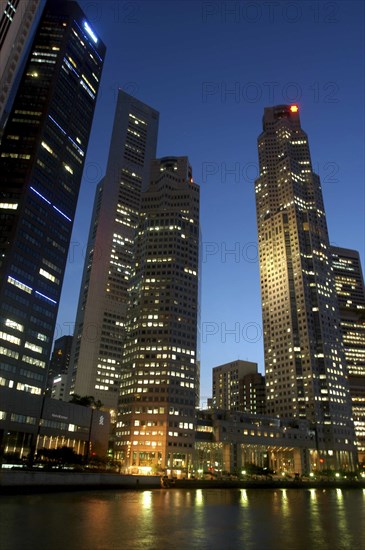 SINGAPORE, Raffles City, City skyline illuminated at dusk