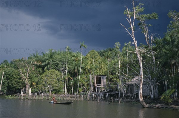 BRAZIL, Amazonas, Amazon Basin, View toward riverside Cabloclo settlement with dark storm clouds overhead