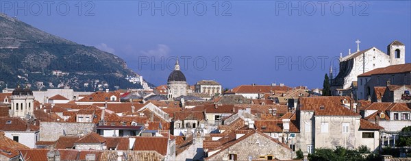 CROATIA, Dalmatia, Dubrovnik, View through a slit in the City Walls over the rooftops looking toward the Cathedral dome