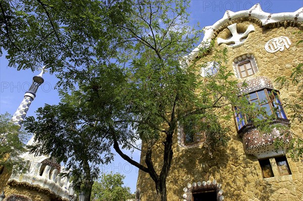 SPAIN, Catalonia, Barcelona, Gaudi architecture seen through trees in Parc Guell