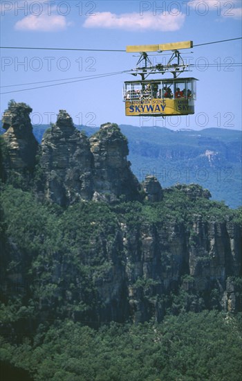 AUSTRALIA, New South Wales, Blue Mountains, The Skyway gondola passing the famous Three Sisters outliers of the great cliffs at Katoomba