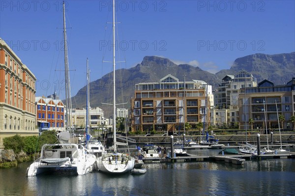 SOUTH AFRICA, Western Cape, Cape Town, View of the waterfront with moored boats and buildings against a backdrop of mountains