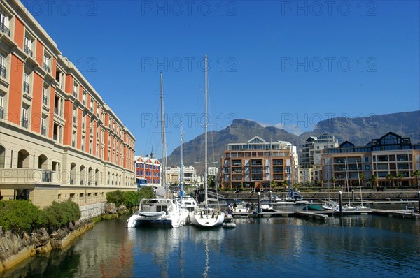 SOUTH AFRICA, Western Cape, Cape Town, View of the waterfront with moored boats and buildings against a backdrop of mountains