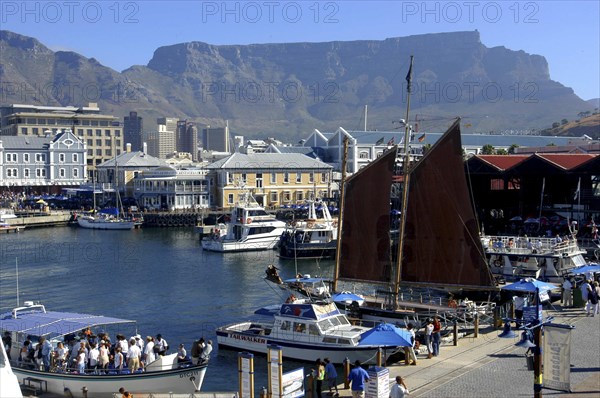 SOUTH AFRICA, Western Cape, Cape Town, View over the waterfront area with busy tourist boats and Table Mountain in the background