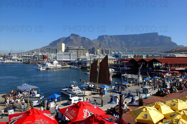 SOUTH AFRICA, Western Cape, Cape Town, View over the waterfront area with brightly coloured umbrellas in the foreground and Table Mountain in the background