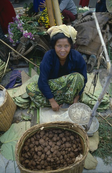 MYANMAR, Yaungshwe, Woman selling rice cakes at street market near Inle Lake.