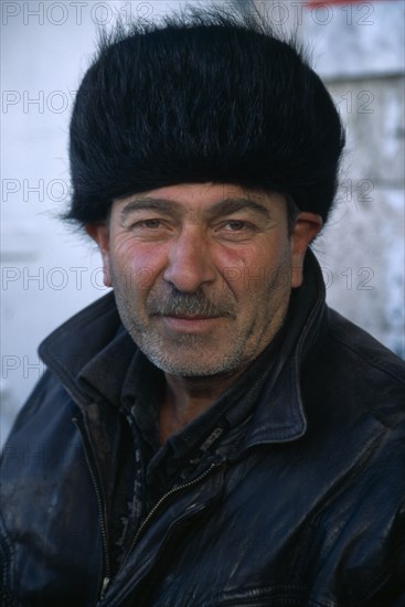 KAZAKHSTAN, Astana, Man in fur hat.  Head and shoulders portrait.