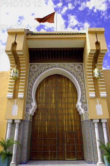 MOROCCO, Marrakech, Exterior of building door with flag flying on roof