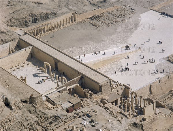 EGYPT, Nile Valley, Thebes, Hatshepsut Mortuary Temple. Deir el-Bahri. Elevated view from limestone cliffs over the temple with visitors walking towards ramped entrance