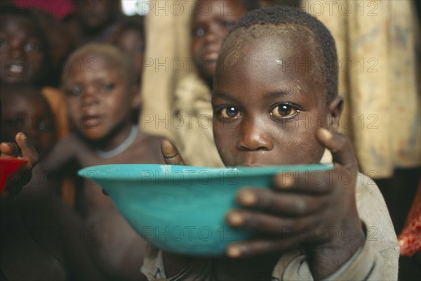 UGANDA, Moroto, Karamoja.  Feeding project for vulnerable people.  Child receiving bowl.
