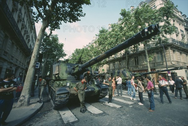 FRANCE, Ile de France, Paris, Bastille Day celebrations on July 14th.  Crowds looking at tanks in city street.