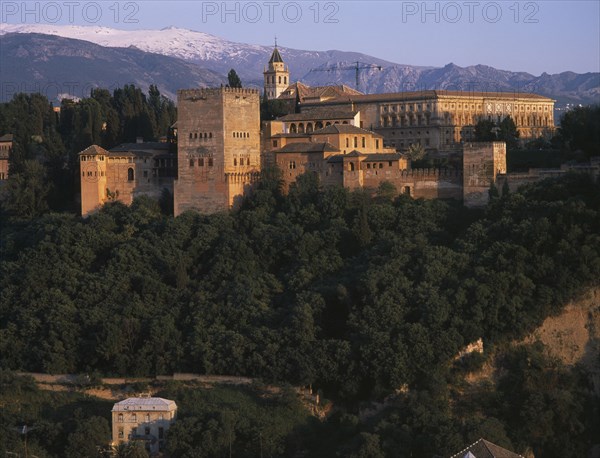 SPAIN, Andalucia, Granada, Alhambra Palace seen from Mirador San Nicolas in evening light with Palacio de Carlos V on the right