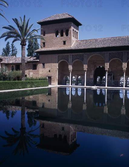 SPAIN, Andalucia, Granada, The Alhambra. Palace of the Maids general view of the tower reflected in the pond