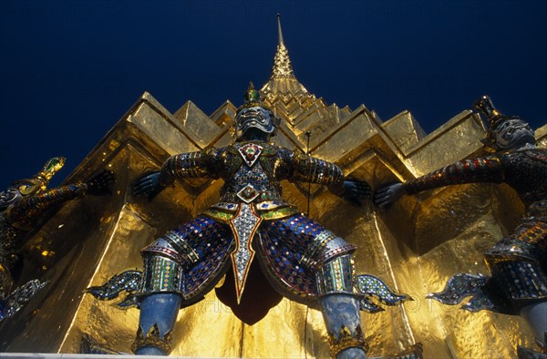 THAILAND, Bangkok, Grand Palace. Demon statue at the base of a spire or prang.