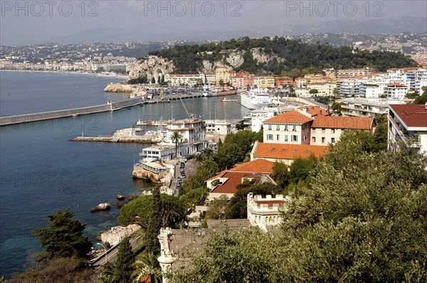 FRANCE, Cote d Azur, Nice, View over rooftops and harbour with the coastline beyond