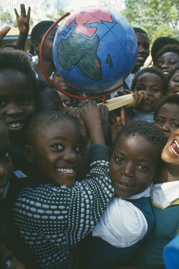 MALAWI, Blantyre, School children with globe made by Pamet paper making project which produce fair trade goods from recycling everything from newspaper to elephant dung.
