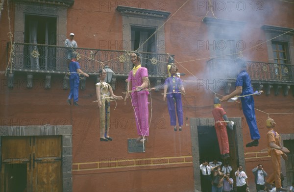 MEXICO, Guanajuato, San Miguel de Allende, Exploding papier mache figures of Judas hanging from balconies in Plaza Principal during Easter celebrations.