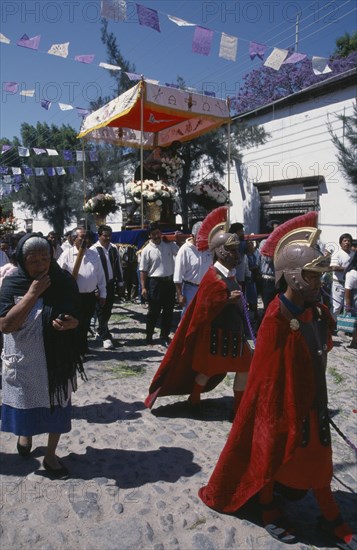 MEXICO, Guanajuato, San Miguel de Allende, Templo de San Juan de Dios.  Easter procession with people dressed as Roman centurions and others carrying figure of Christ on flower strewn platform.