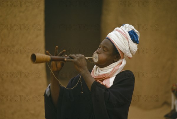 NIGERIA, Katsina, Musician playing traditional flute at the Sallah day celebrations marking the end of the month long Ramadan period of fasting.