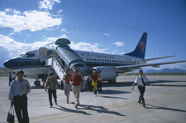 CHINA, Yunnan , Dali, Domestic aircraft on runway with passengers disembarking.