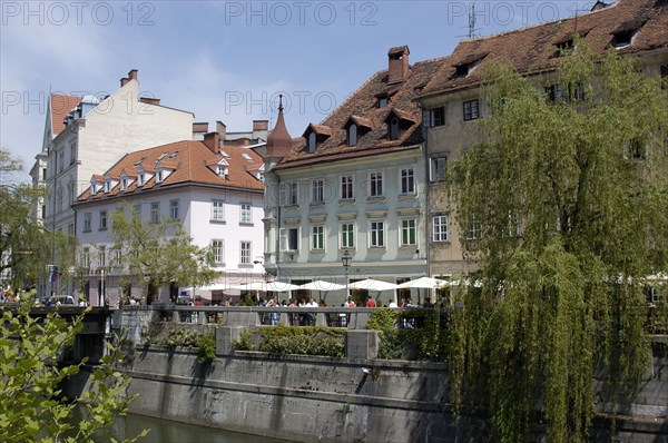 SLOVENIA, Ljubljana, River Ljubljanica. View along row of riverside cafes toward the old town