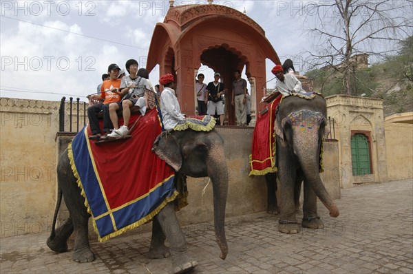 INDIA, Rajasthan, Jaipur, Japanese tourists taking elephant ride with mounting platform behind them