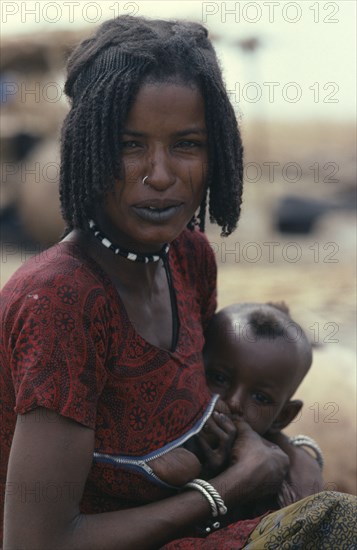 NIGERIA, North, Shua Arab woman breast feeding her child wearing a special breast feeding dress with a horizontal opening across her chest