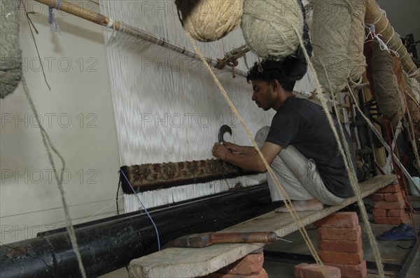 INDIA, Rajasthan, Jaipur, Man weaving a Rajastan carpet on a large loom