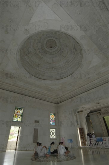 INDIA, Rajasthan, Jaipur, Interior view of Laxmi Narayan Temple with devotees sitting on the floor under the beautifully decorated marble domed ceiling