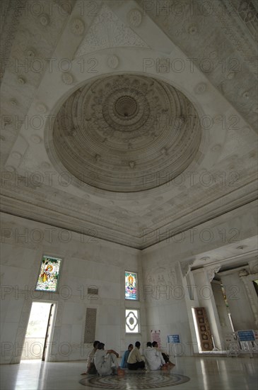 INDIA, Rajasthan, Jaipur, Interior view of Laxmi Narayan Temple with devotees sitting on the floor under the beautifully decorated marble domed ceiling