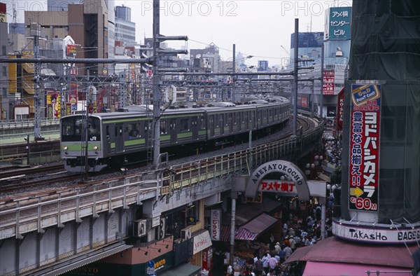 JAPAN, Honshu, Tokyo, Train travelling along the elevated tracks above the Ameyayokocho market street