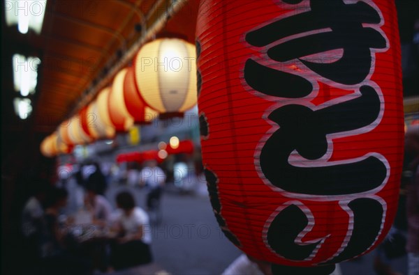 JAPAN, Honshu, Tokyo, Close up view along a row of lanterns illuminated outside an Asakusa area restaurant