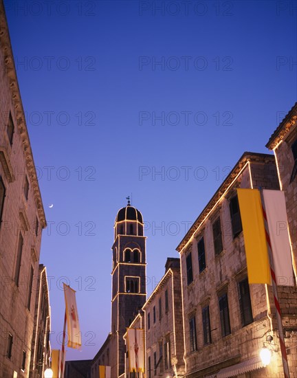 CROATIA, Dalmatia, Dubrovnik, View along the Stradun toward the Francisan Monastery tower illuminated at dusk