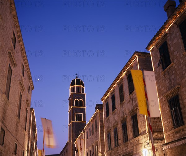 CROATIA, Dalmatia, Dubrovnik, View along the Stradun toward the Francisan Monastery tower illuminated at dusk