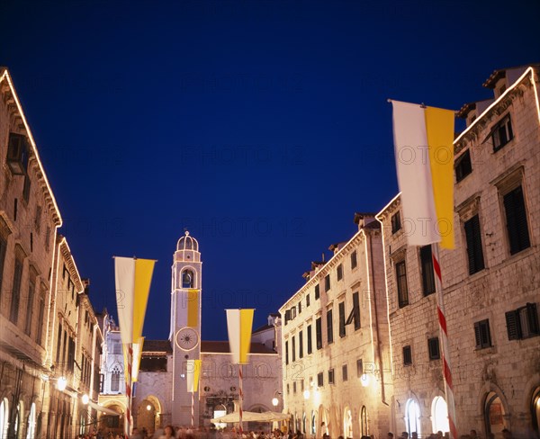CROATIA, Dalmatia, Dubrovnik, View along the Stradun toward the clocktower with Vatican flags for the papal visit June 2003