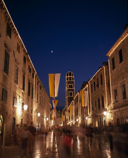 CROATIA, Dalmatia, Dubrovnik, View along the Stradun toward the Franciscan Monastery illuminated at night