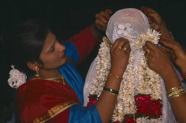 INDIA , Rajasthan, Udaipur, Veiled Moslem bride being garlanded by women