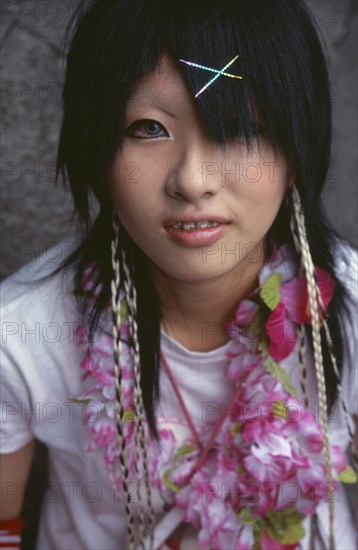 JAPAN, Honshu, Tokyo, Harajuku District. Portrait of a teenage girl wearing a flower garland and sparkling hairclips