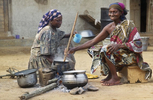 GHANA, Cooking, "Women cooking banku a fermented corn and cassava dough cooked to a paste in hot water and served with soup, stew or a pepper sauce with fish."