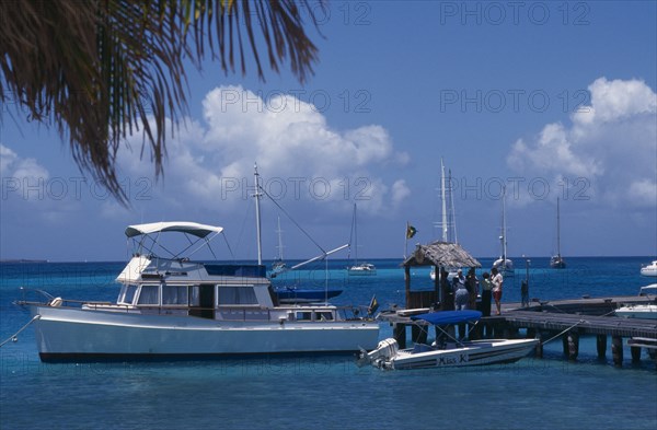 GRENADINES, Petit St Vincent, Moored yacht at the end of a wooden jetty