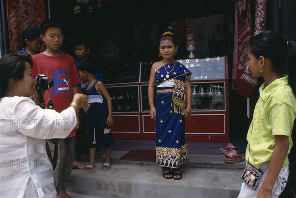 LAOS, Luang Prabang, Little girl in traditional dress waiting to have her photograph taken at New Year.