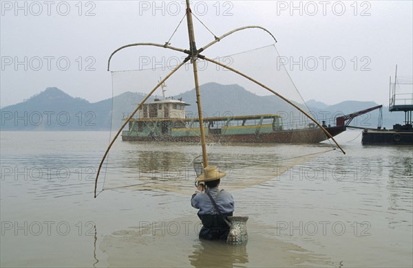 CHINA, Hubei Province, Yichang, Man fishing in the Yangtze River