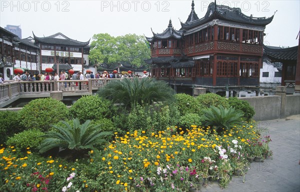 CHINA, Shanghai, Wuxingting Teahouse set in pond at the Mandarin Gardens Bazaar or Yuyuan with visiting crowds on bridge leading to it.