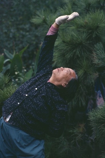 CHINA, Shanghai, Elderly woman doing Tai Chi exercises