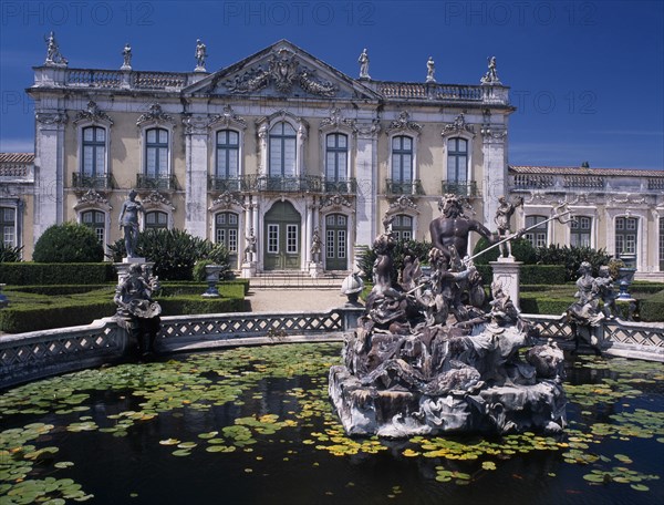 PORTUGAL, Near Lisbon, Palacio Nacional de Queluz facade with pond and central statue in the foreground.