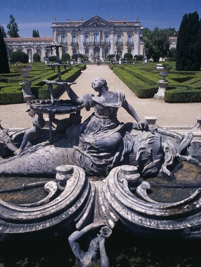 PORTUGAL, Near Lisbon, Palacio Nacional de Queluz facade with fountain statue in the foreground and formal gardens.