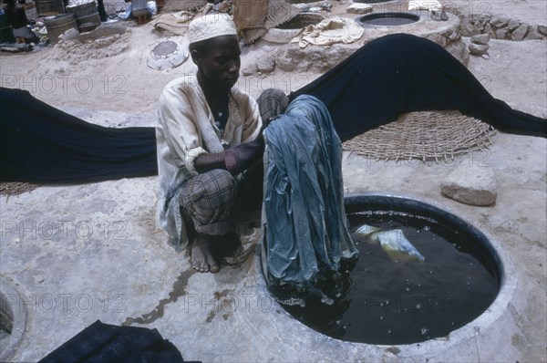 NIGERIA, Kano, Man working in the indigo dye pits