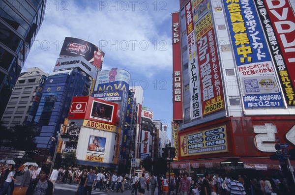 JAPAN, Honshu, Tokyo, Shinjuku. View of advertisement covered architecture in busy city street scene