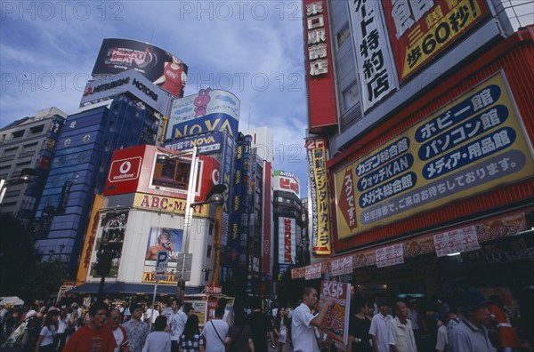 JAPAN, Honshu, Tokyo, Shinjuku. View of advertisement covered architecture in busy city street scene